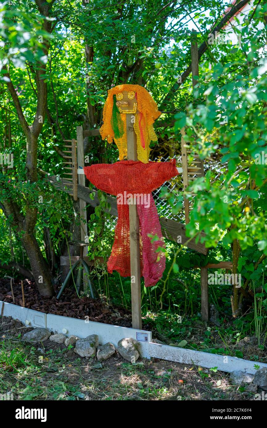 Home made, DIY, colourful scarecrow in the garden trying to scare