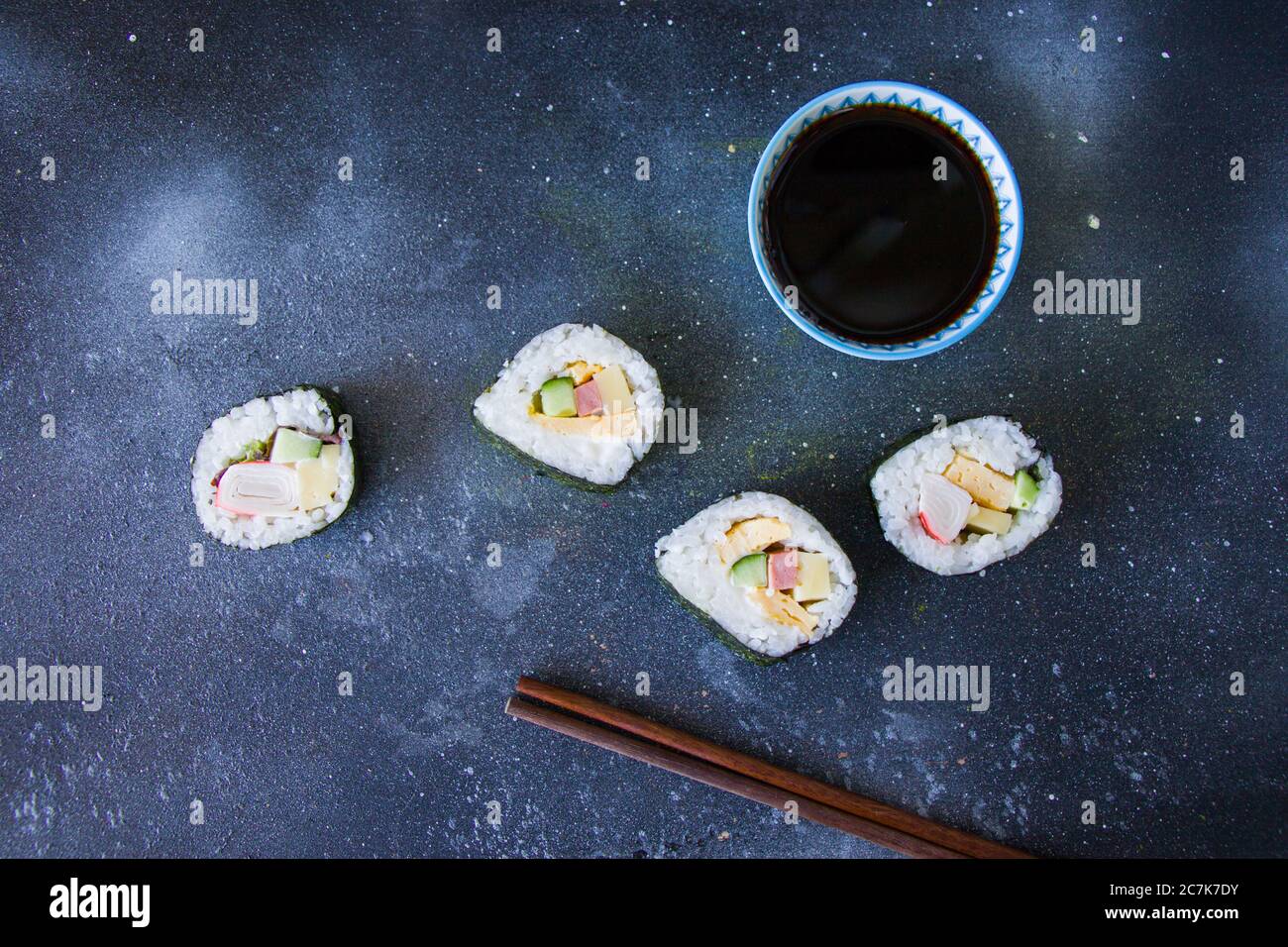 Kimbab or kimbap on the blue background with soy souse, blue background, studio shoot, natural light. Stock Photo