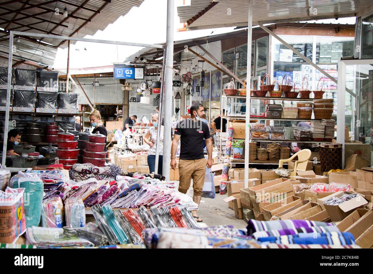 People in open air marketplace and shop, objects and things on the shelf’s in Lilo, Tbilisi, Georgia . Shopping scene. Stock Photo