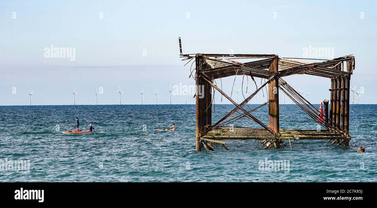 Brighton UK 18th July 2020 - Paddle boarders pass by the West Pier in Brighton this morning on a beautiful sunny day on the South Coast with temperatures expected to reach the high 20s in some parts of Britain : Credit Simon Dack / Alamy Live News Stock Photo