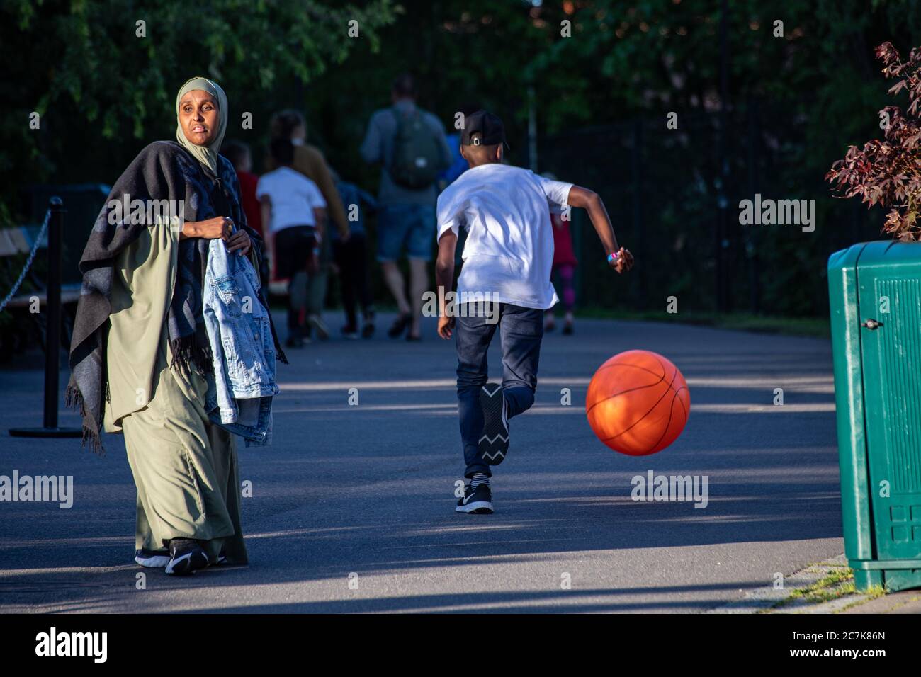 Middle-aged mother and a teenage boy with giant basket ball Stock Photo