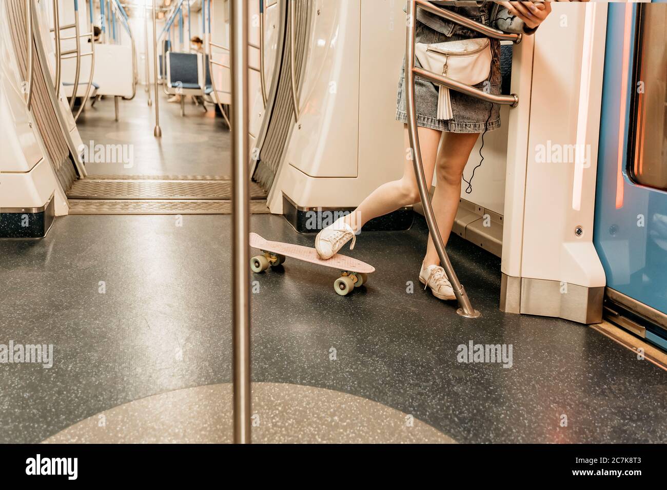 a young girl in a short skirt with a skate rides in an electric train, legs  close-up Stock Photo - Alamy