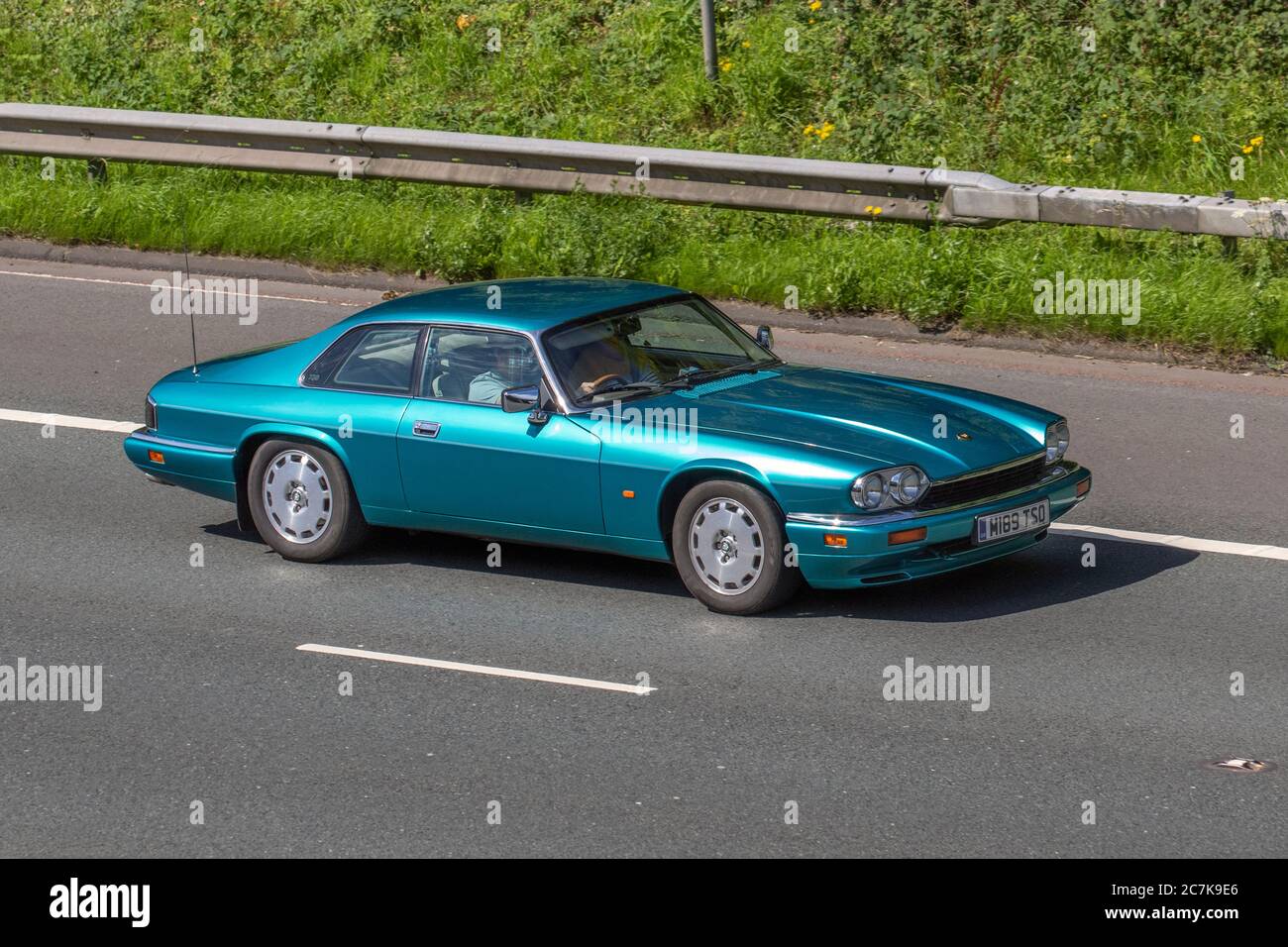 1995 90s Turquoise Jaguar Xj-S 4.0 Auto; Vehicular traffic moving vehicles, cars driving vehicle on UK roads, motors, motoring on the M6 motorway highway network. Stock Photo