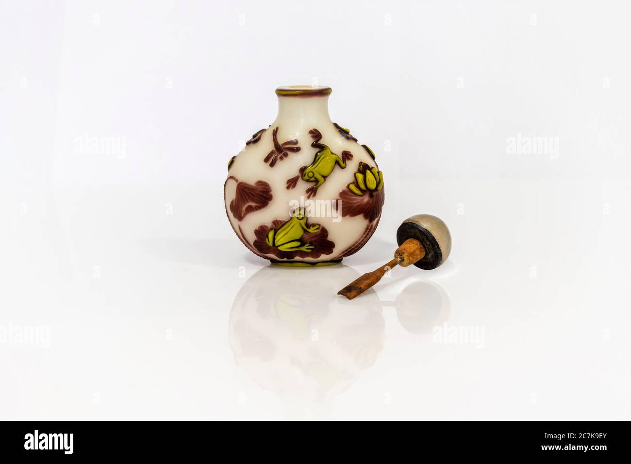 Chinese glass snuff bottle with frog or toad, lotus and dragonfly motifs. Clipping path. Stock Photo