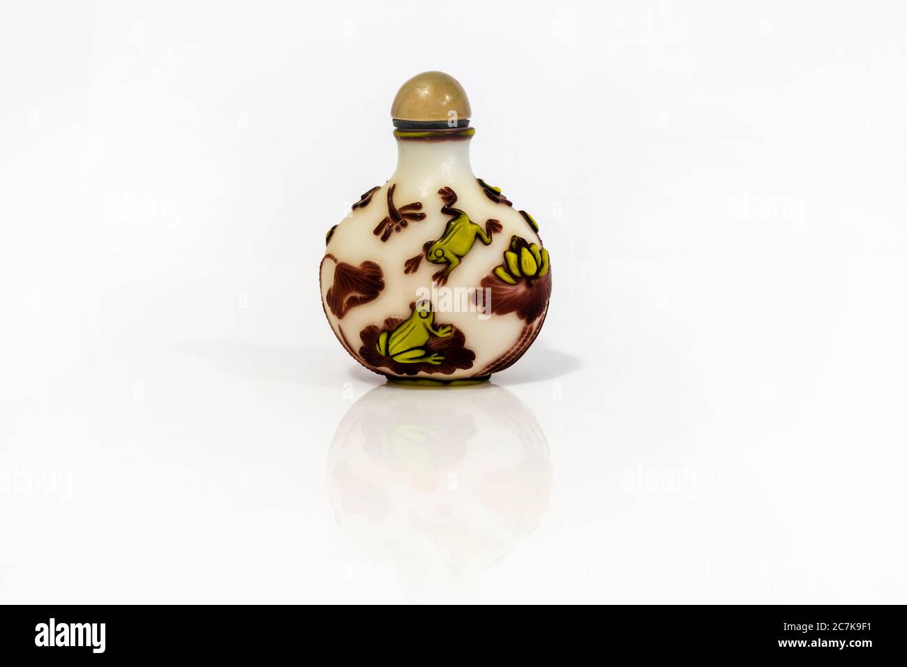 Chinese glass snuff bottle with frog or toad, lotus and dragonfly motifs. Clipping path. Stock Photo