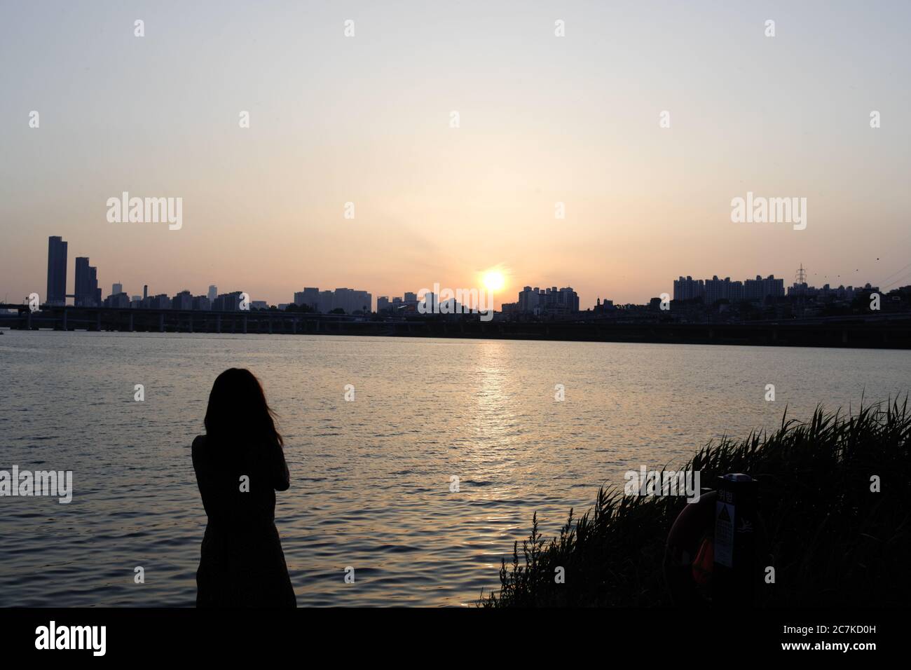 Lonely Riverside Lonely girl woman looking at the riverside on a windy evening on the ...