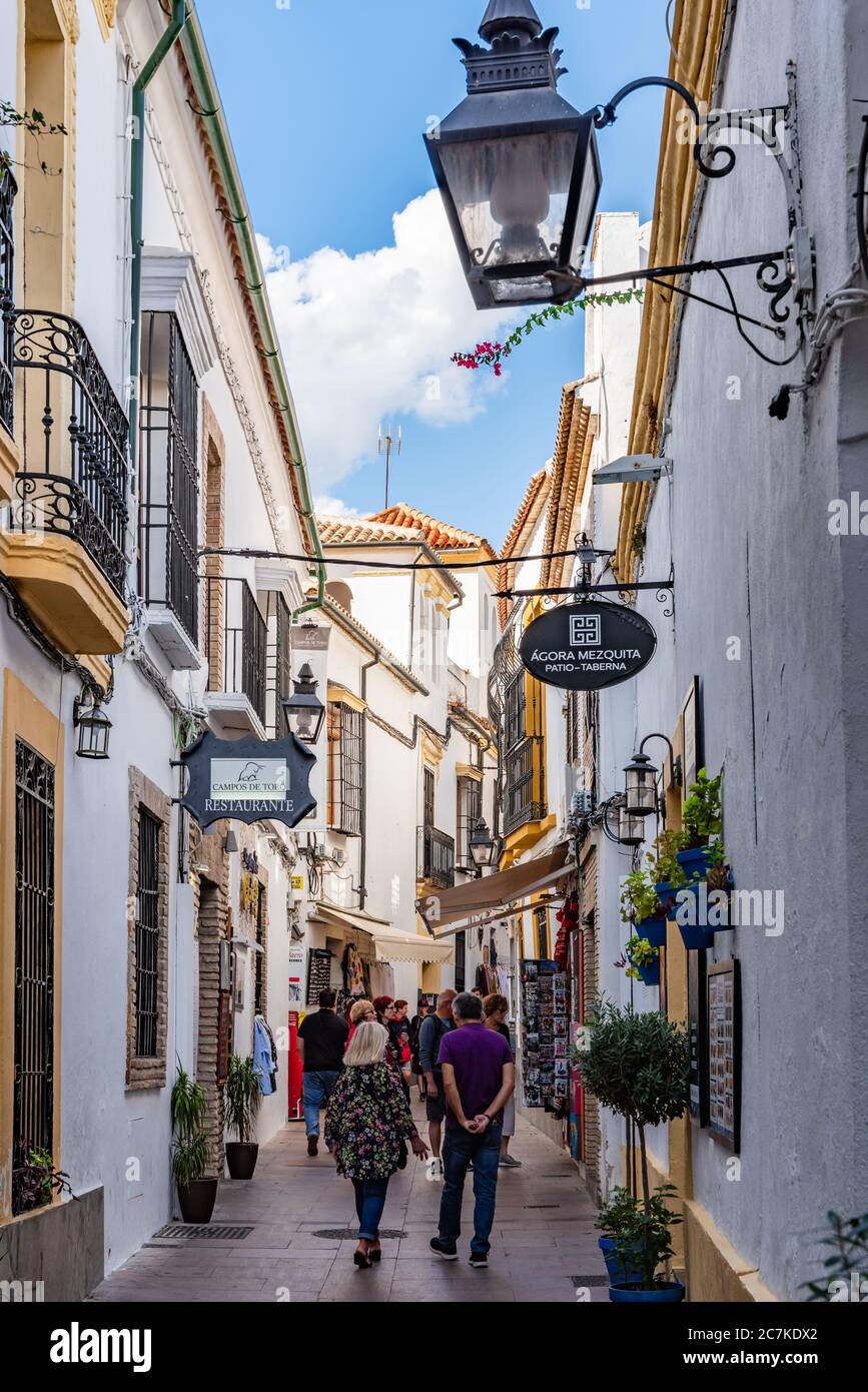 Restaurants and shops line Cordoba's narrow, winding, Calle Cespedes as it snakes its way from the historic Mosque-Cathedral. Stock Photo