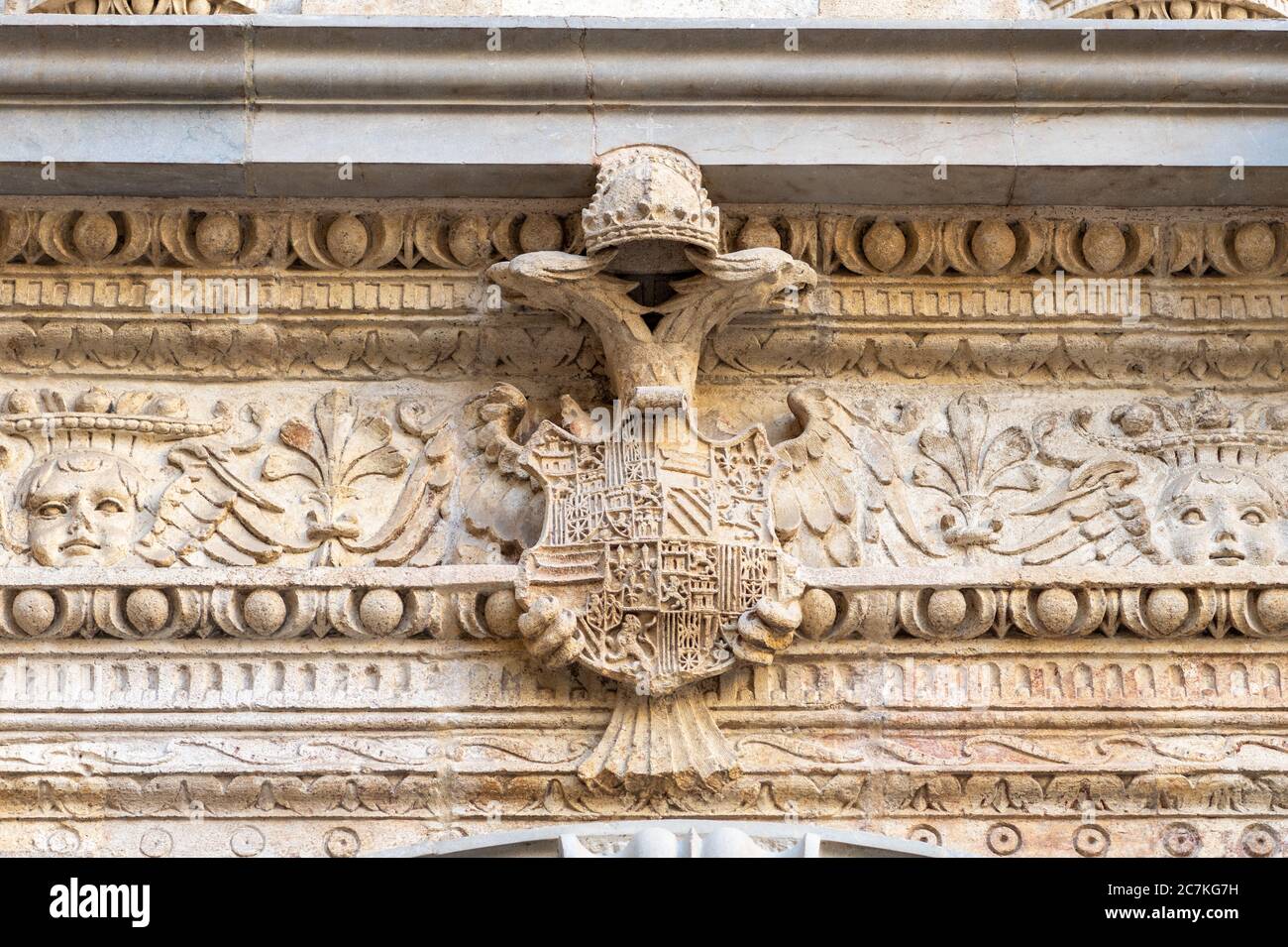 The carved twin-headed eagle crest of Ferdinand of Aragon and Isabella of Castile decorates the entablature of the Royal Chapel of Granada Stock Photo