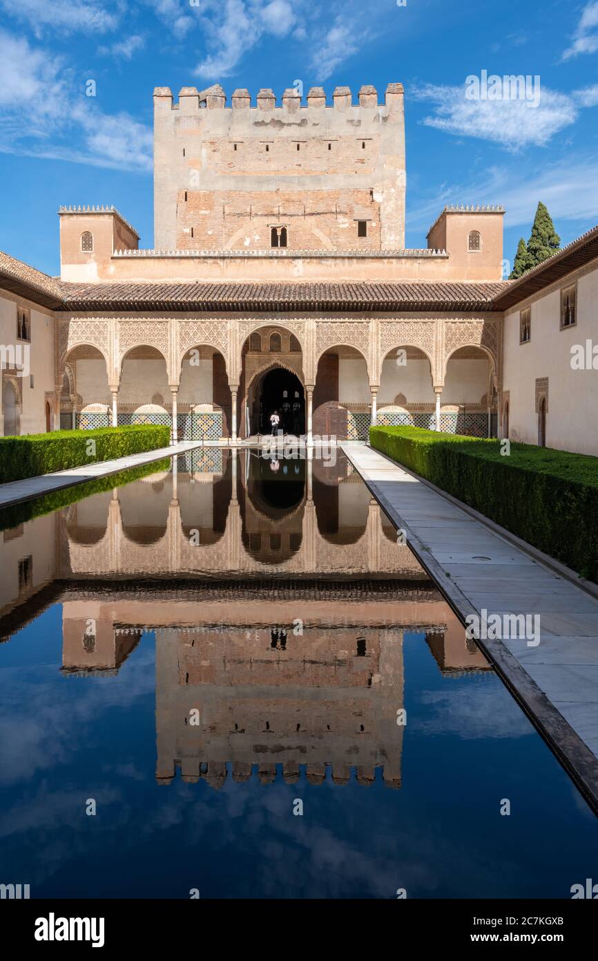A mirror of water in the Courtyard of the Myrtles reflects the crenelated Comares Tower and North Gallery of the Comares Palace. Stock Photo