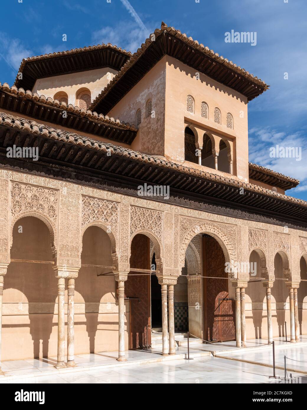 The Hall of the Two Sisters rises above the facade of ornate arches in the Courtyard  of the Lions Stock Photo