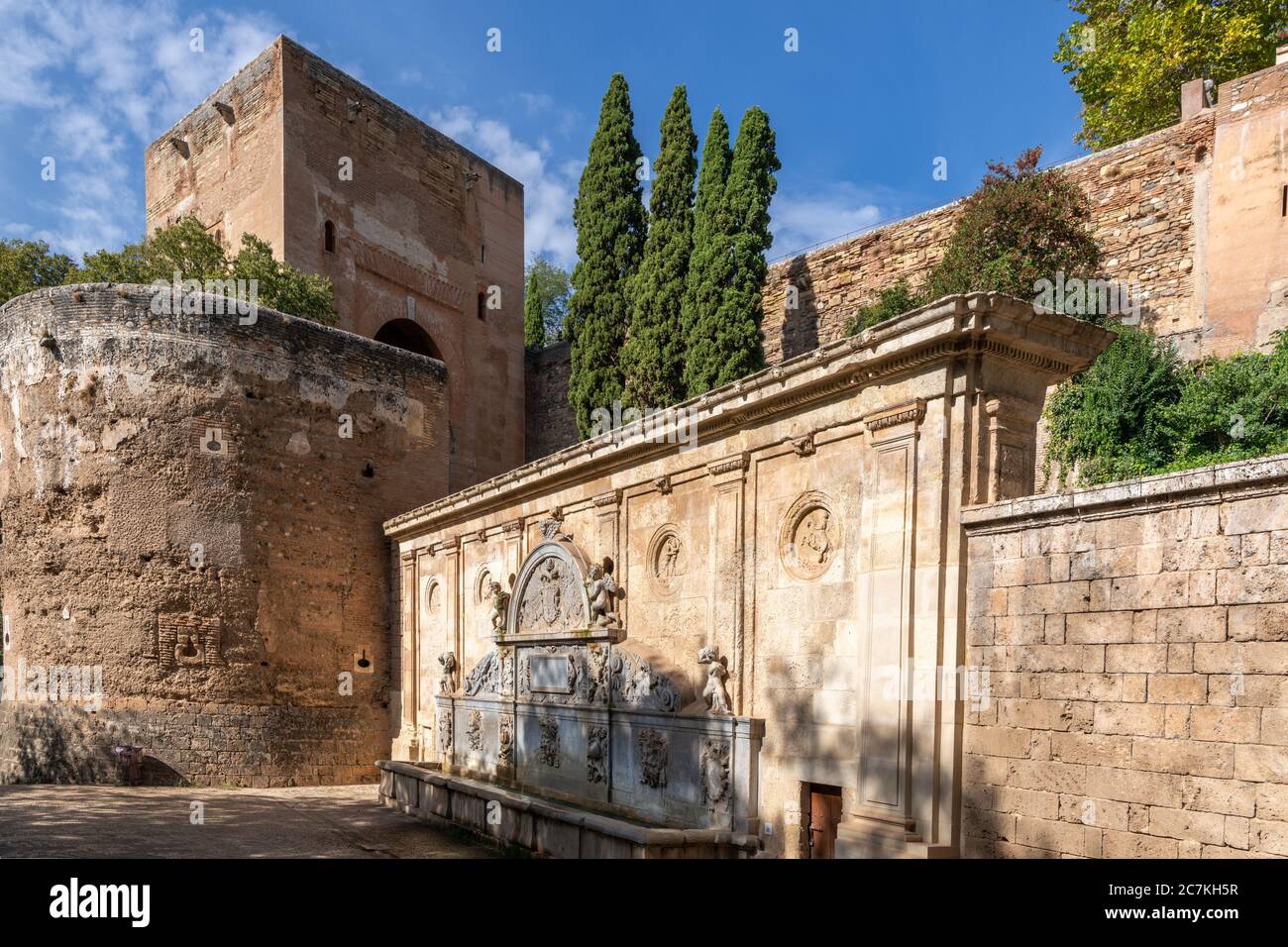 Alhambra's Puerta de la Justicia rises over Pedro Machuca's ornate Charles V Fountain at the entrance to the historic city. Stock Photo