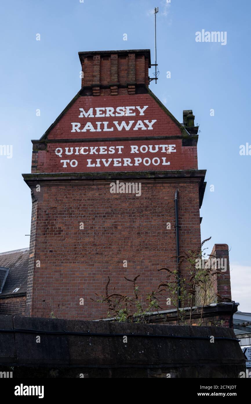 Side of Birkenhead Central train station indicating trains to Liverpool