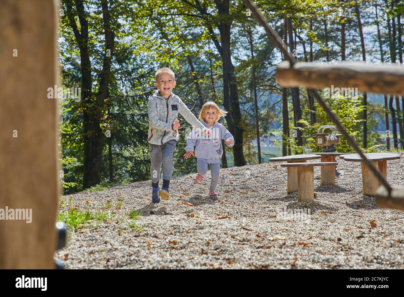 Little boy and a girl happily running in the playground Stock Photo