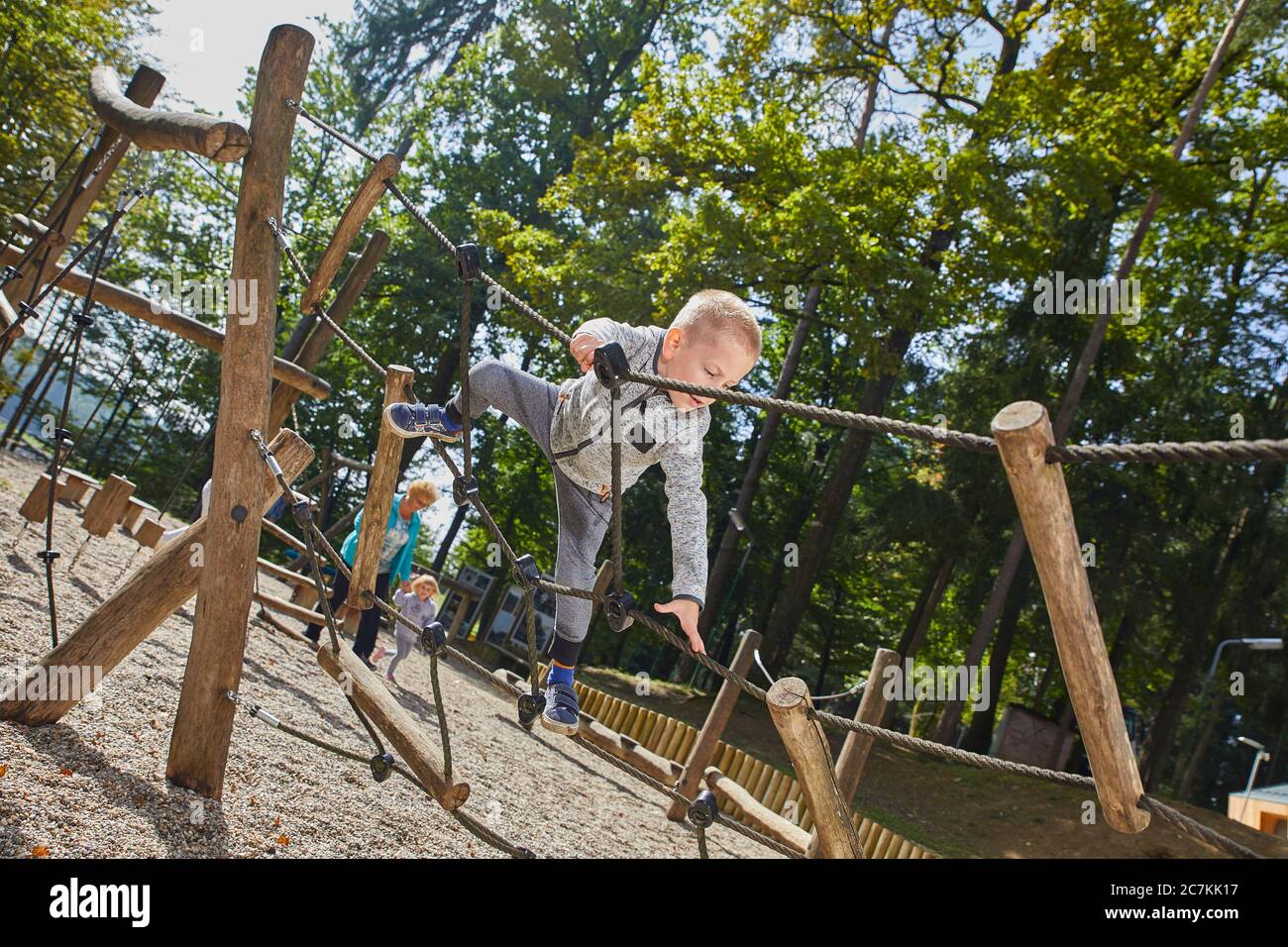 Closeup shot of a little boy climbing on the ropes in the playground Stock Photo