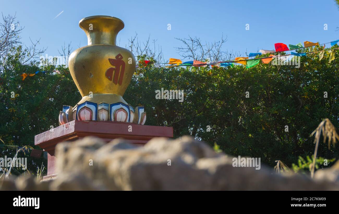 buddhist figure outside with plants Stock Photo