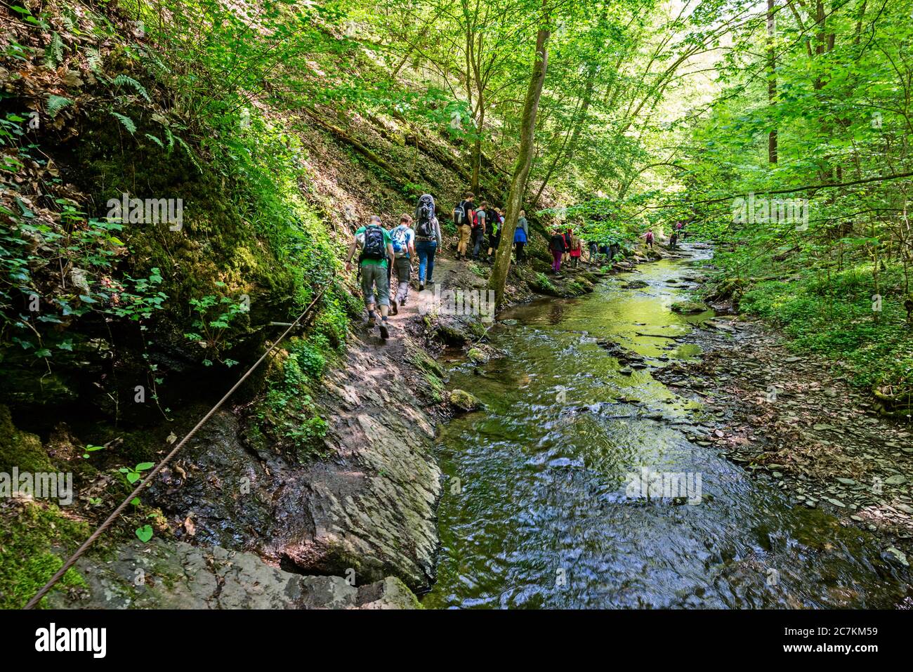 At the narrowest point in the Ehrbachklamm, hikers shimmy along wire ropes Stock Photo