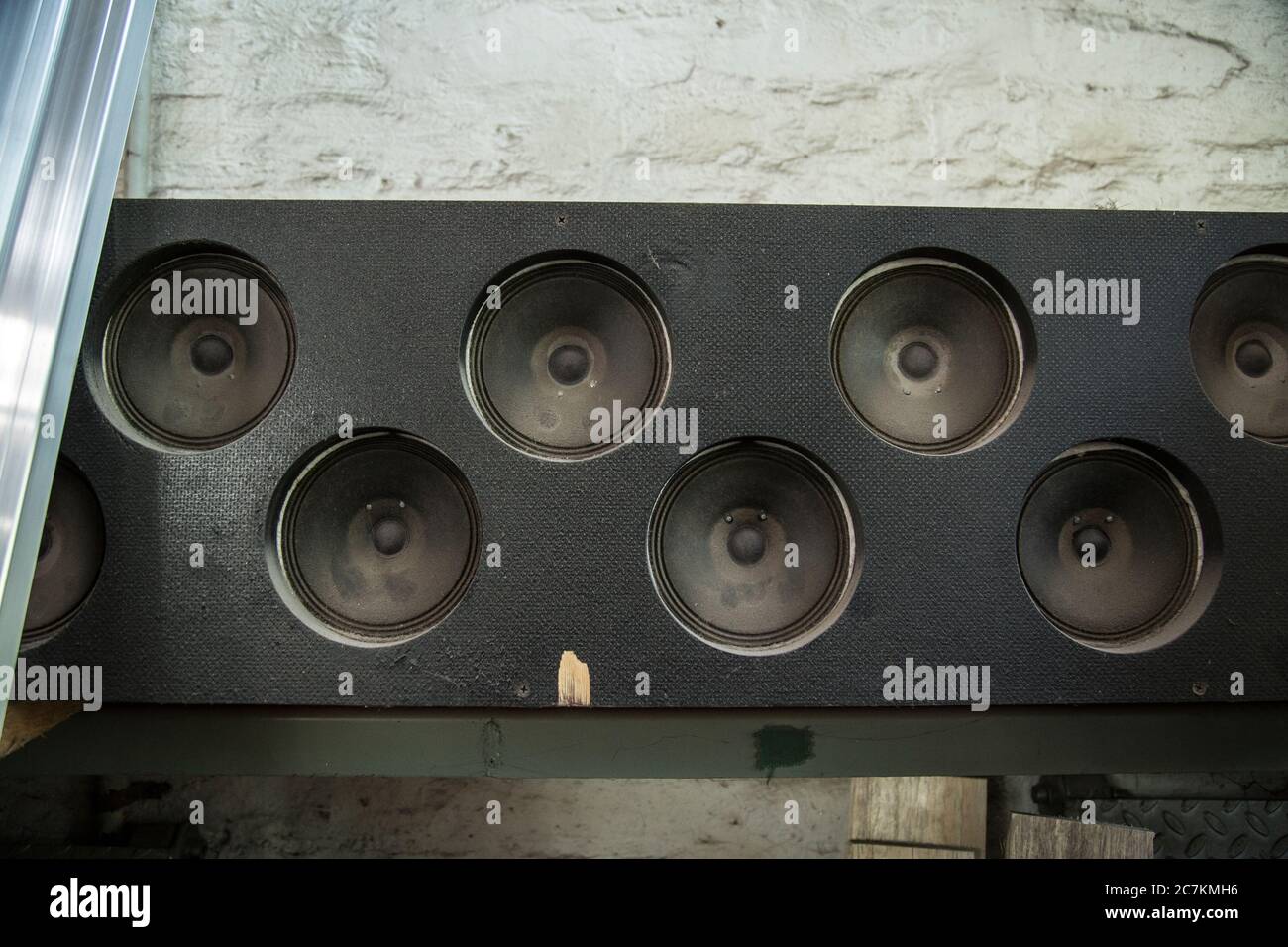 Closeup of old dusty Subwoofers on the wall under the lights Stock Photo