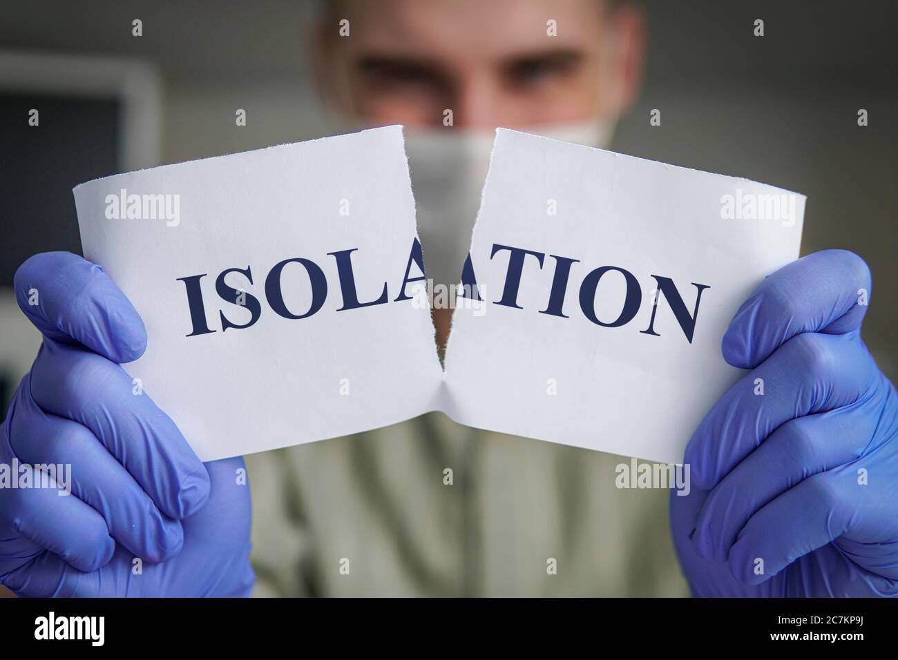 End of a coronavirus isolation concept. man tears paper with word Isolation. Pandemic of COVID-19 is over. Victory over the covid-19 pandemic. Finish Stock Photo