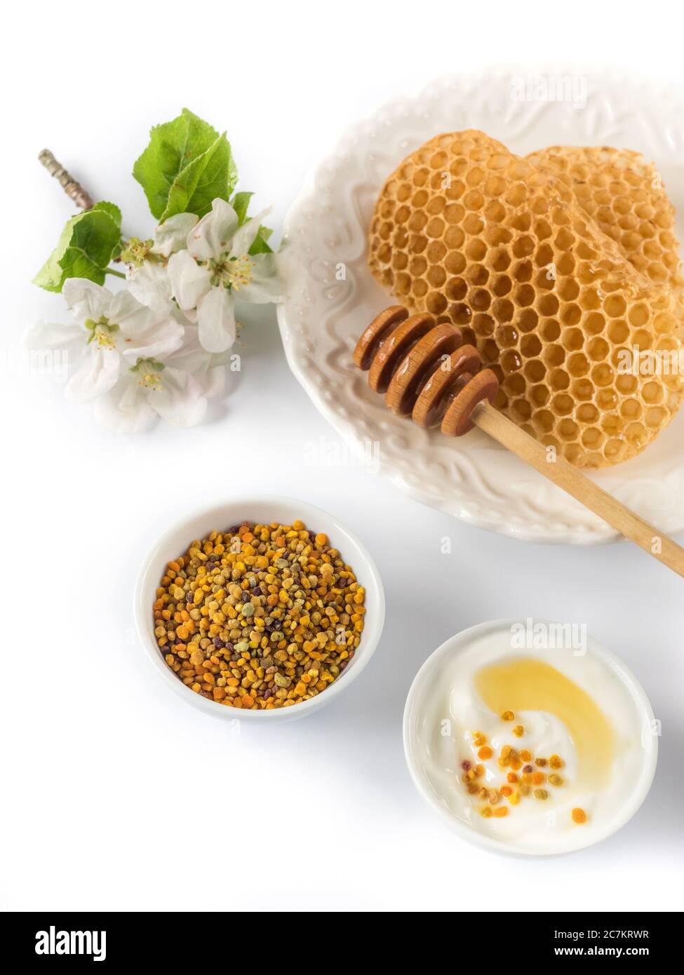 Yoghurt with bee pollen grains and honey in white ceramic bowl on white background. Stock Photo
