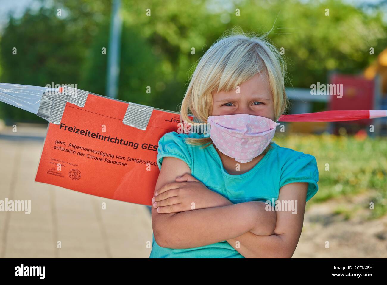 Girl with face mask in front of a playground, Corona crisis, Regensburg, Bavaria, Germany Stock Photo