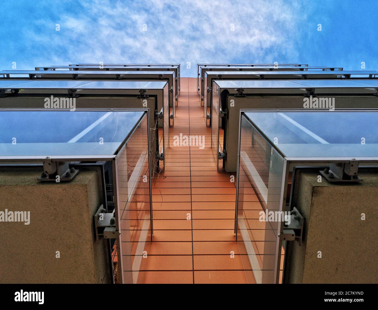 Low angle shot of a modern apartment building with glass supported ...