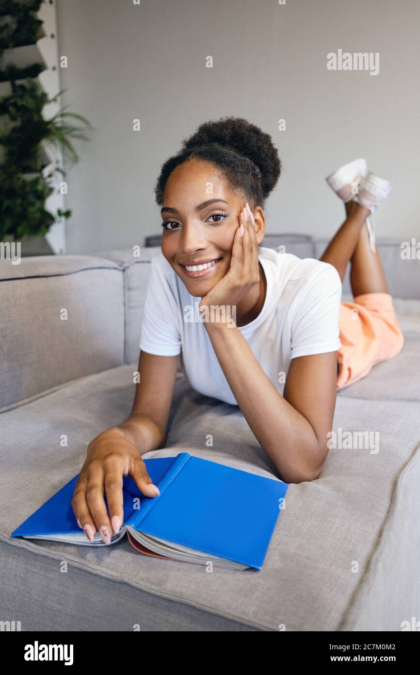 Girl lying on sofa reading hi-res stock photography and images - Alamy