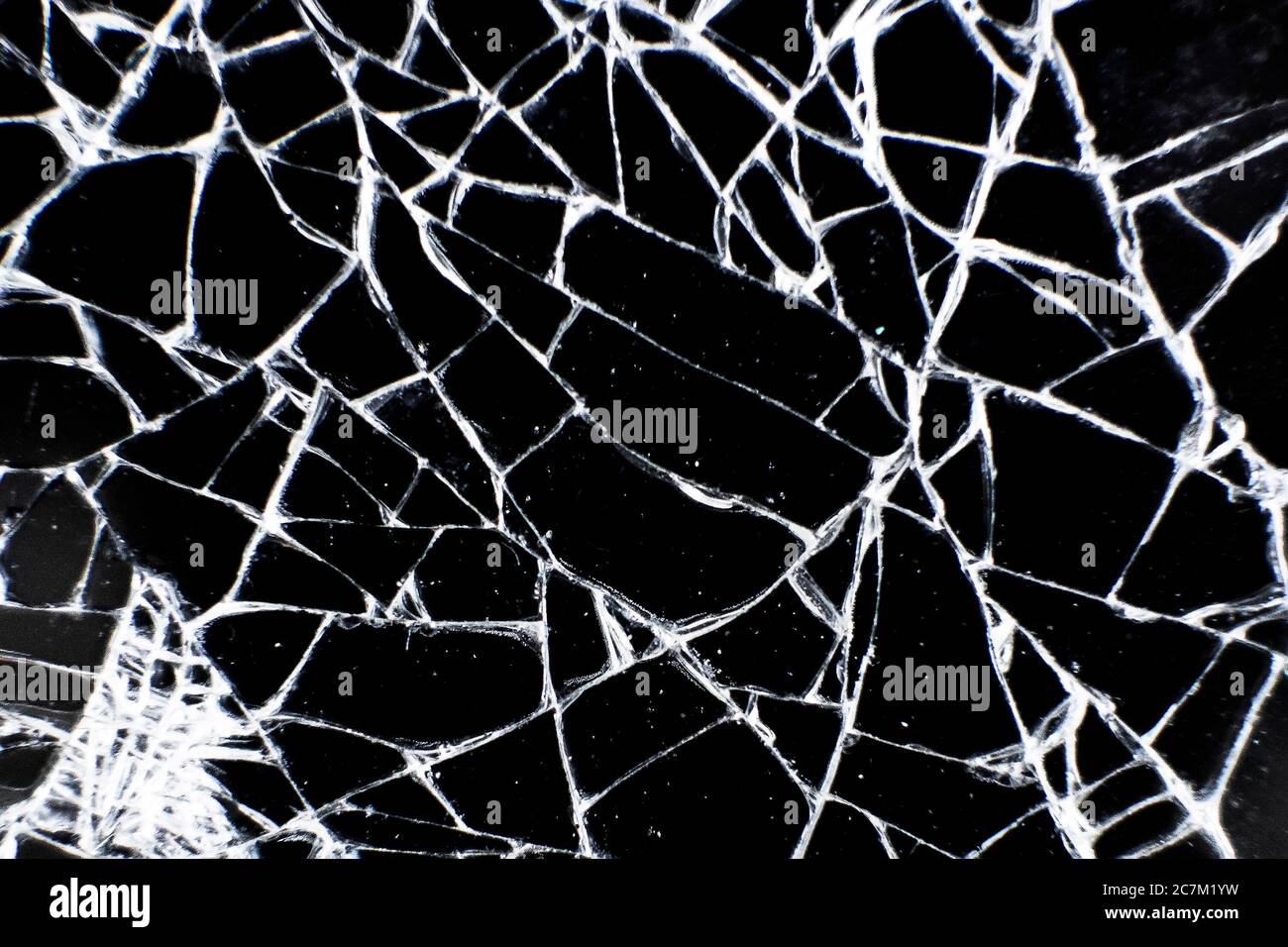Broken glass tablet computer. Cracked screen. Cracks in the glass on black background. Stock Photo