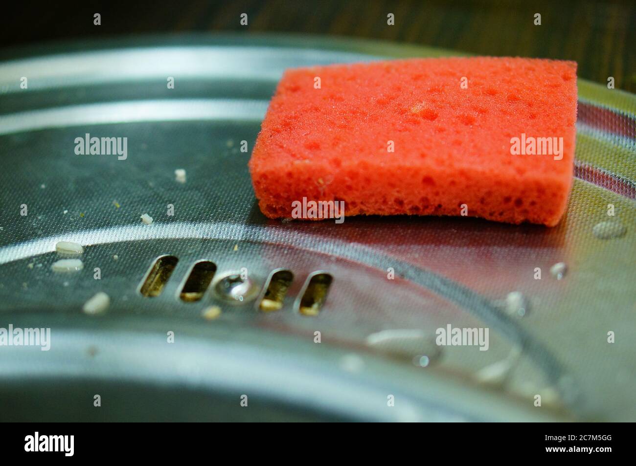Orange sponge placed next to the metal sink Stock Photo Alamy