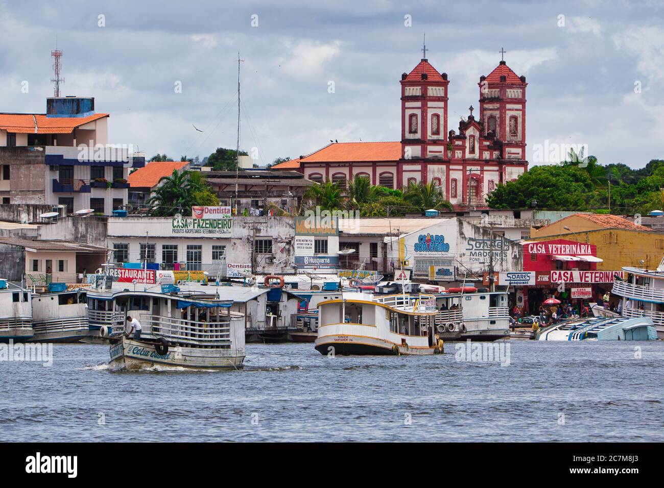 Boats activity on the waterfront of Santarem with a Church beyond, on The River Amazon, Para State, Brazil, Stock Photo