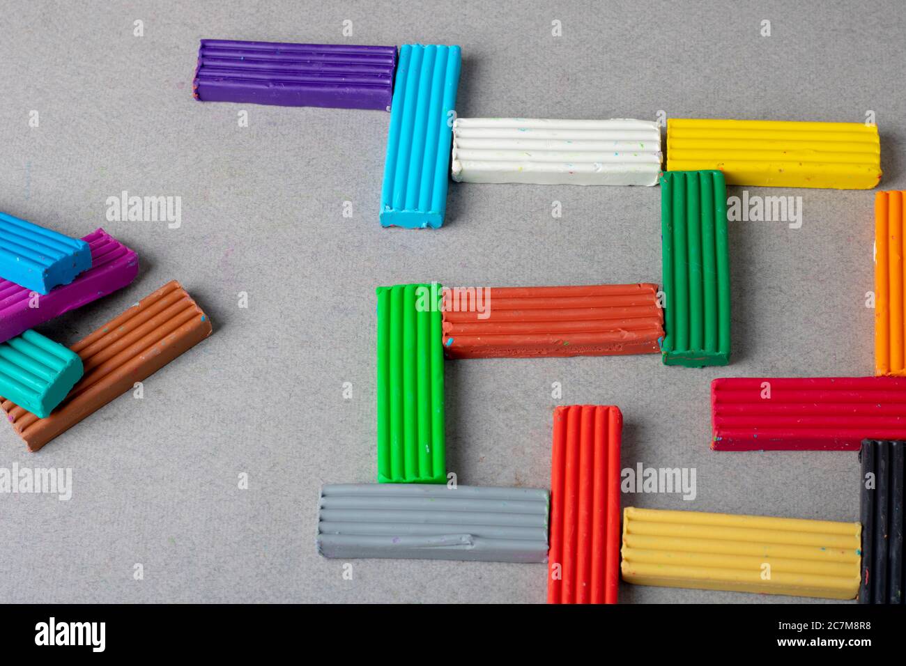 Multi-colored plasticine on grey paper, puzzle concept Stock Photo
