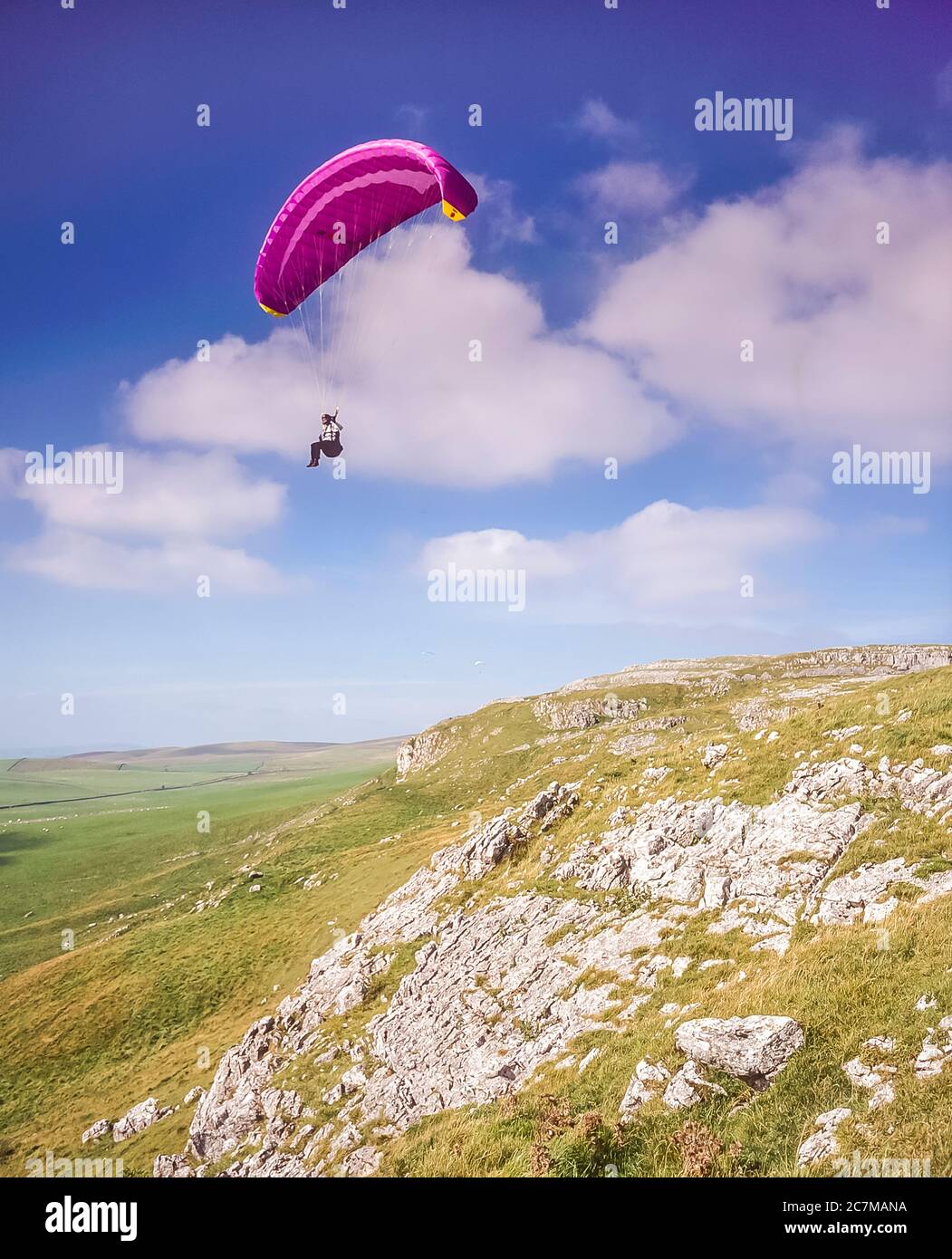 Para gliders ride the thermal air currents rising up over Hunts Cross Scar at Kingsdale not far from the Yorkshire Dales village of Ingleton around 2000 Stock Photo