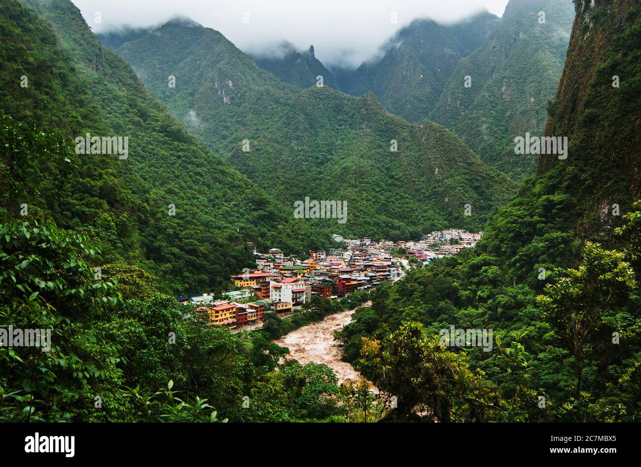 The Urubamba River flowing through the town of Aguas Calientes and the green Andes mountains, Cusco, Peru, South America Stock Photo