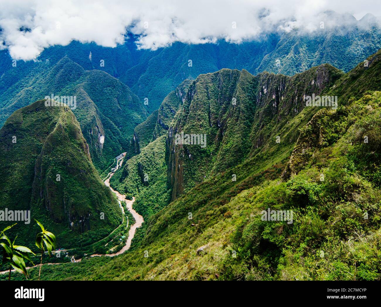 The Urubamba River flowing through the green Andes mountains and the town of Aguas Calientes, Cusco, Peru, South America Stock Photo
