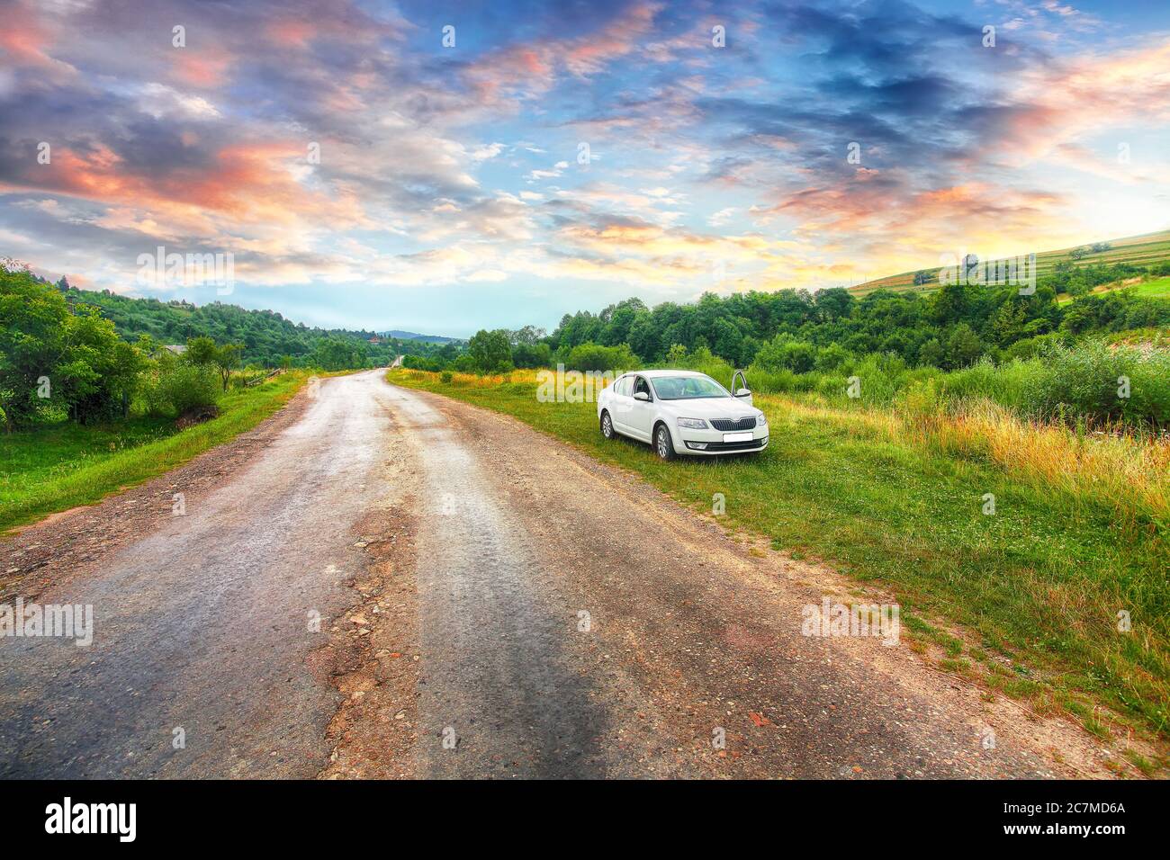 Front-side view of a car on nature background. Dramatic sunset sky. Bad road  Stock Photo - Alamy