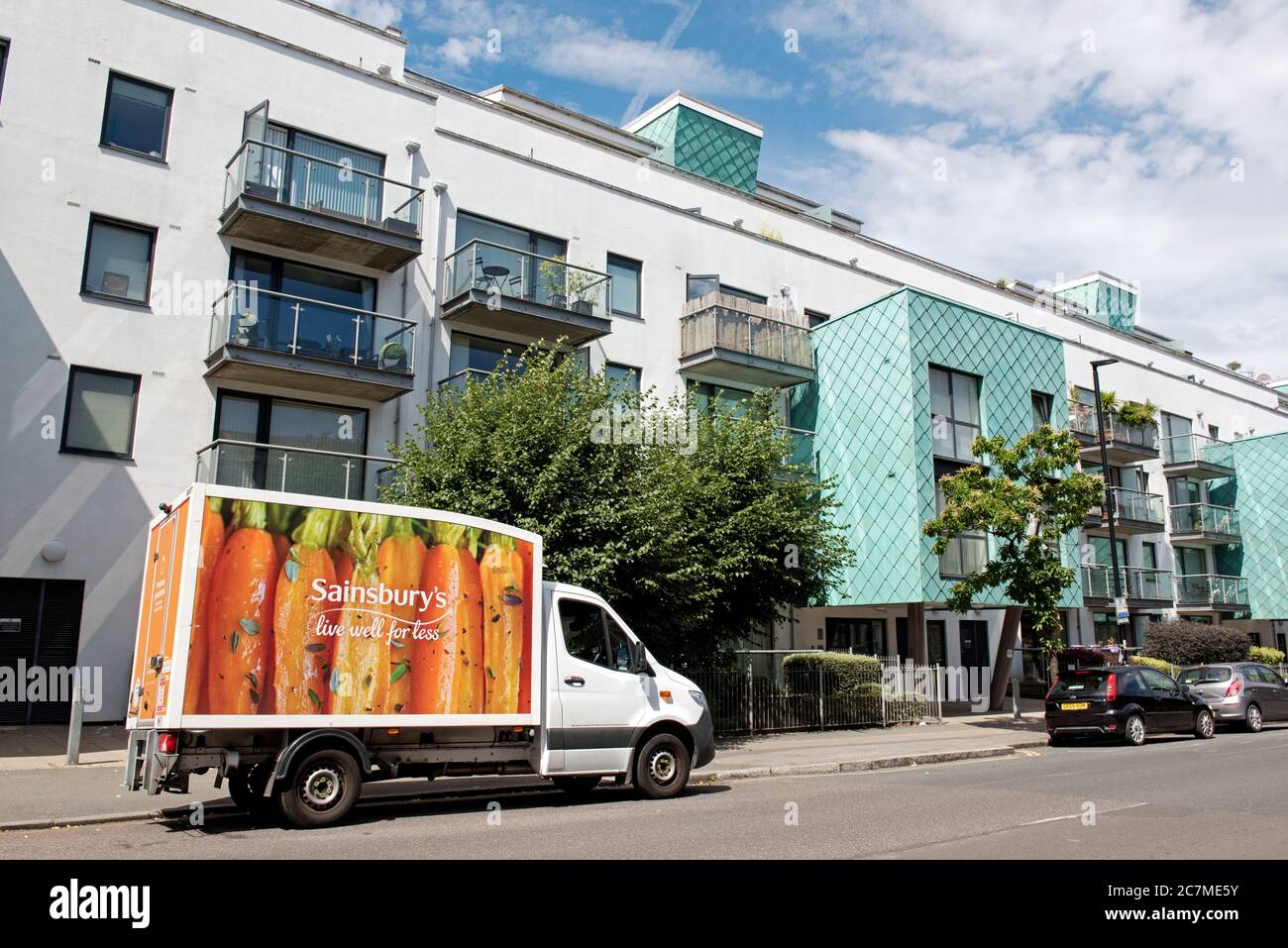 Sainsbury's Delivery Van in Drayton Park an urban street with modern flats behind, Highbury, N5