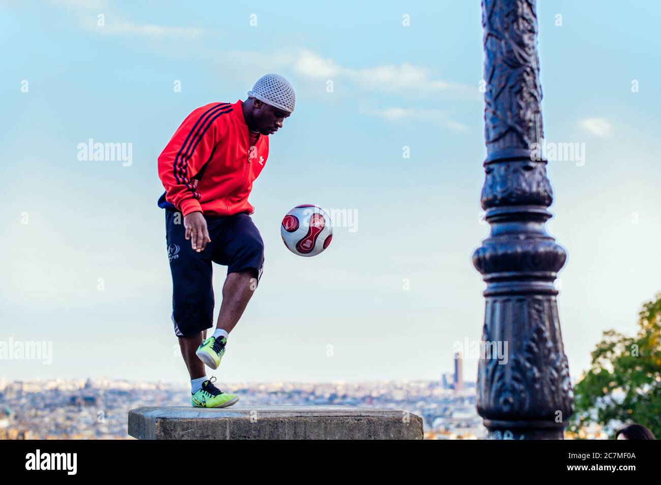PARIS, FRANCE - Jul 13, 2019: A series of images showing a young man performing a show with his football in front of the Sacre Coeur Church in Montmar Stock Photo