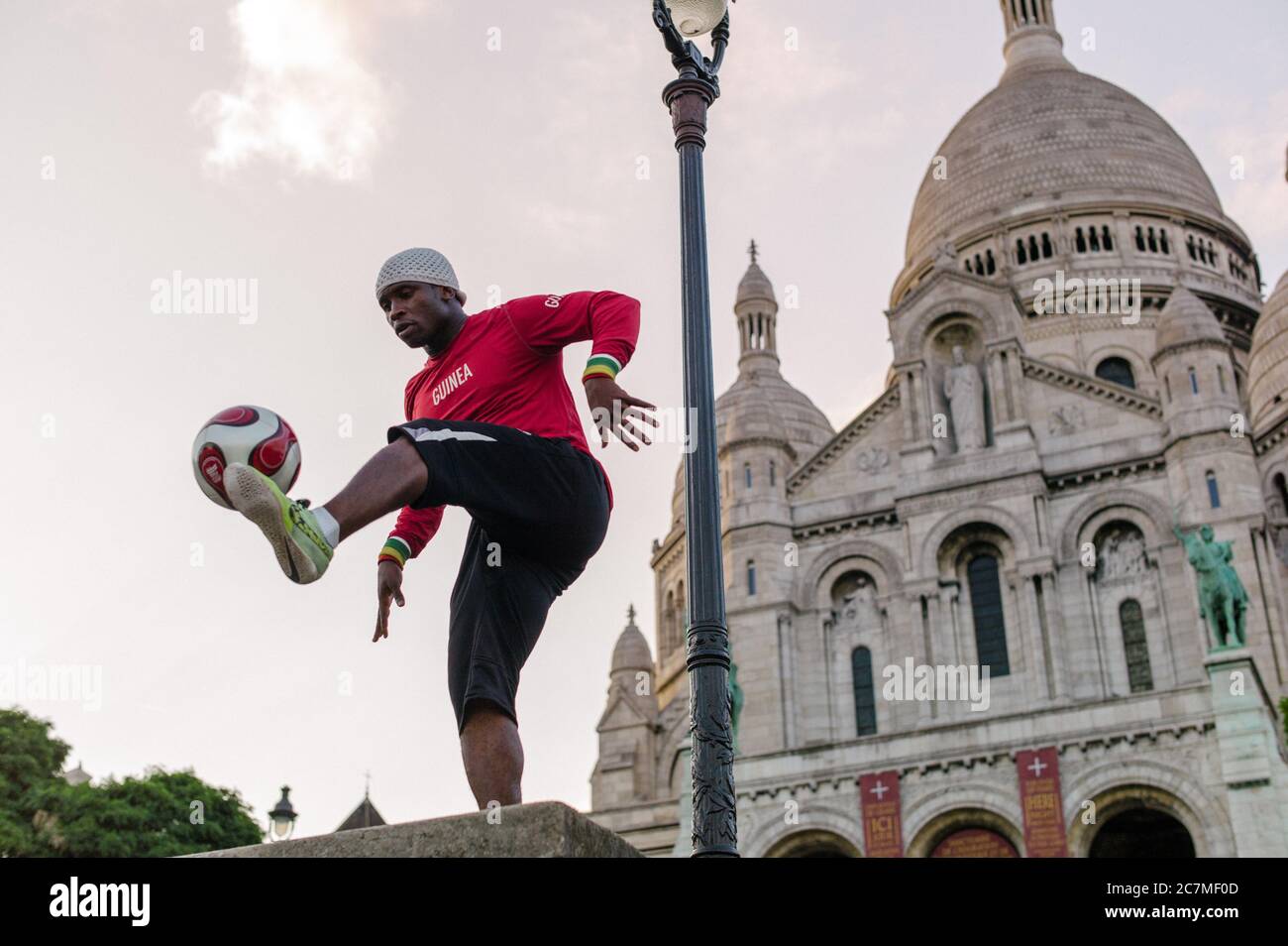 PARIS, FRANCE - Jul 13, 2019: A series of images showing a young man performing a show with his football in front of the Sacre Coeur Church in Montmar Stock Photo