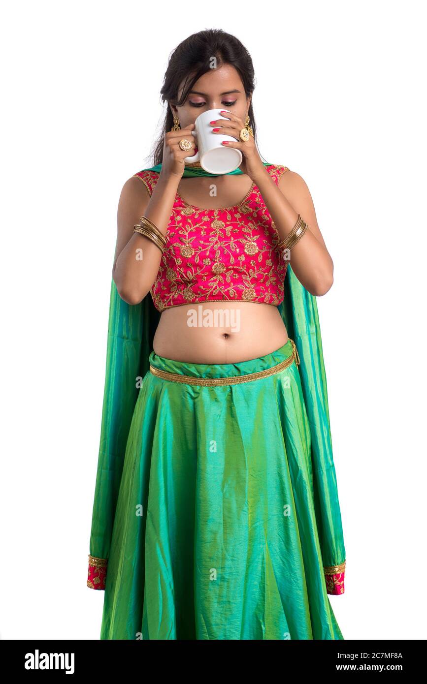 Beautiful young girl with cup of tea or coffee posing on white ...