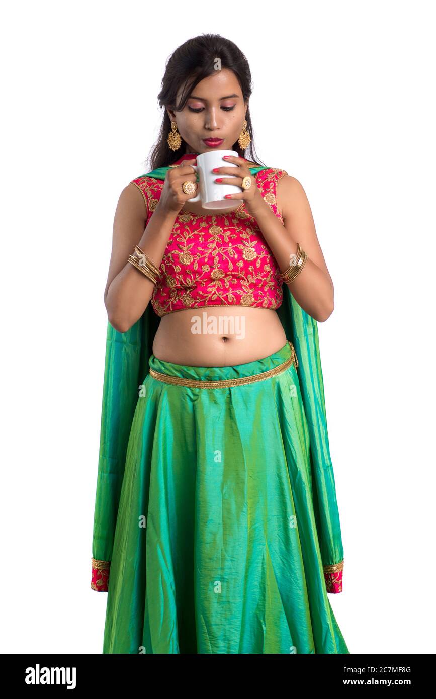 Beautiful young girl with cup of tea or coffee posing on white ...