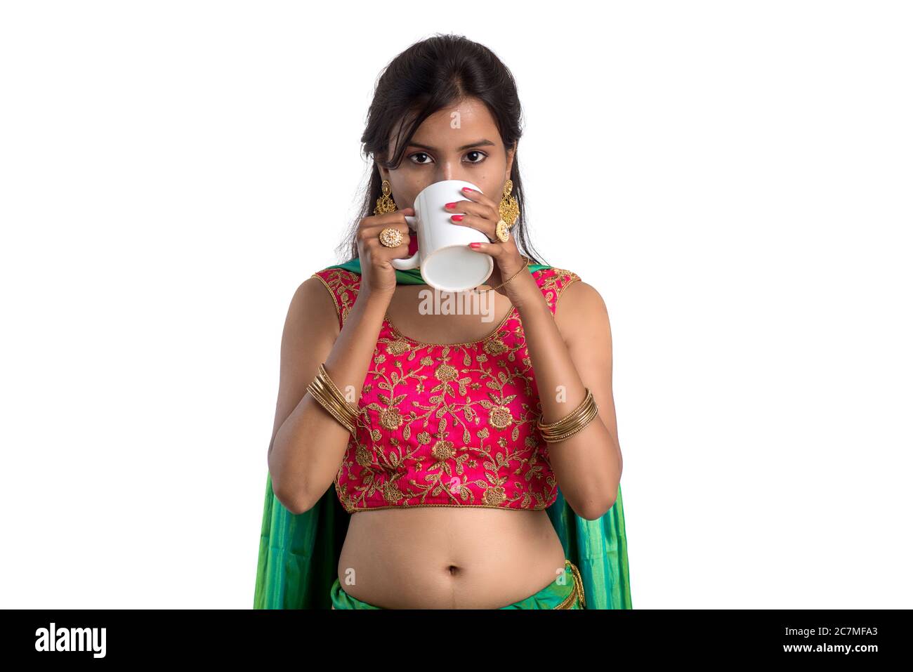 Beautiful young girl with cup of tea or coffee posing on white ...