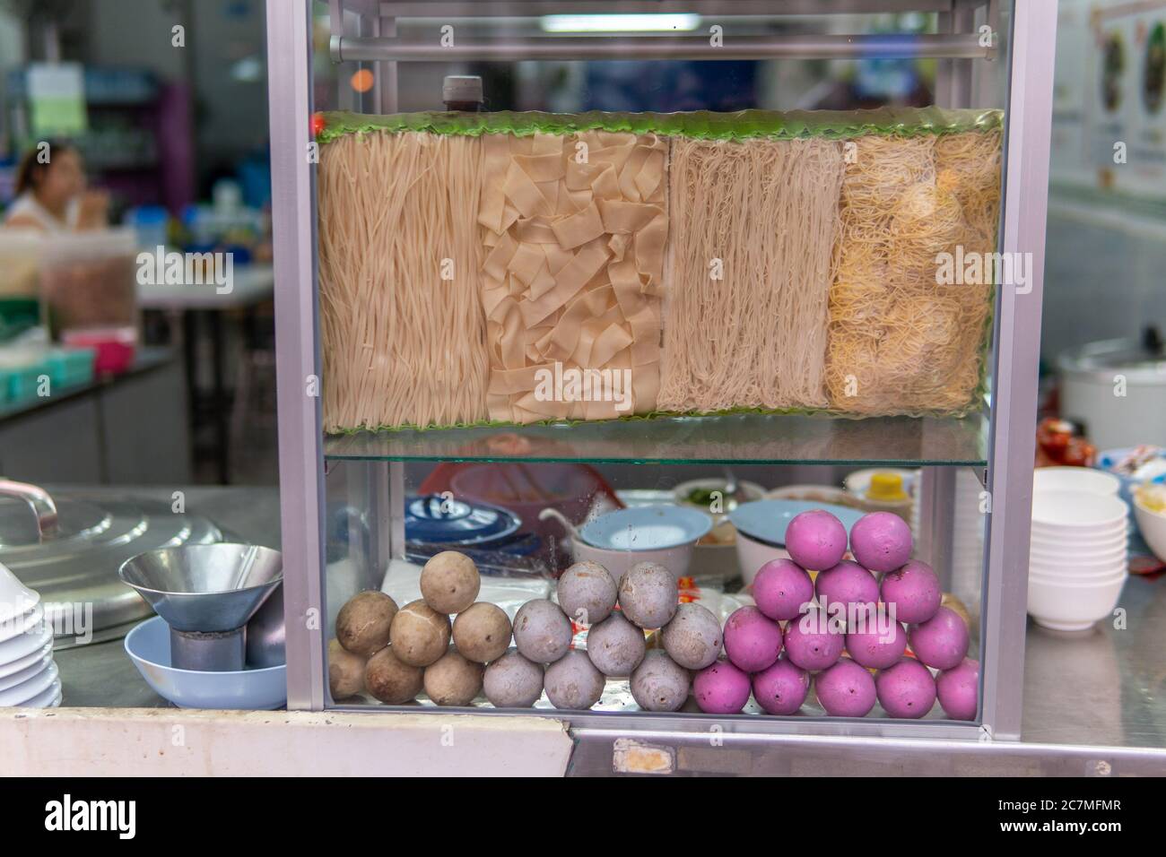 Multiple rice noodles and colored 1000 year old eggs in display case in