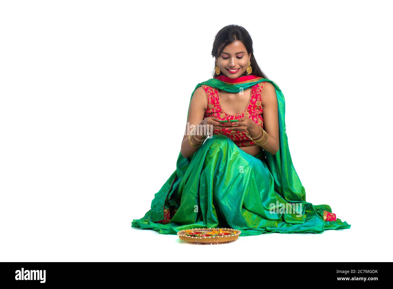 Portrait of a Indian Traditional Girl holding Diya and making Rangoli