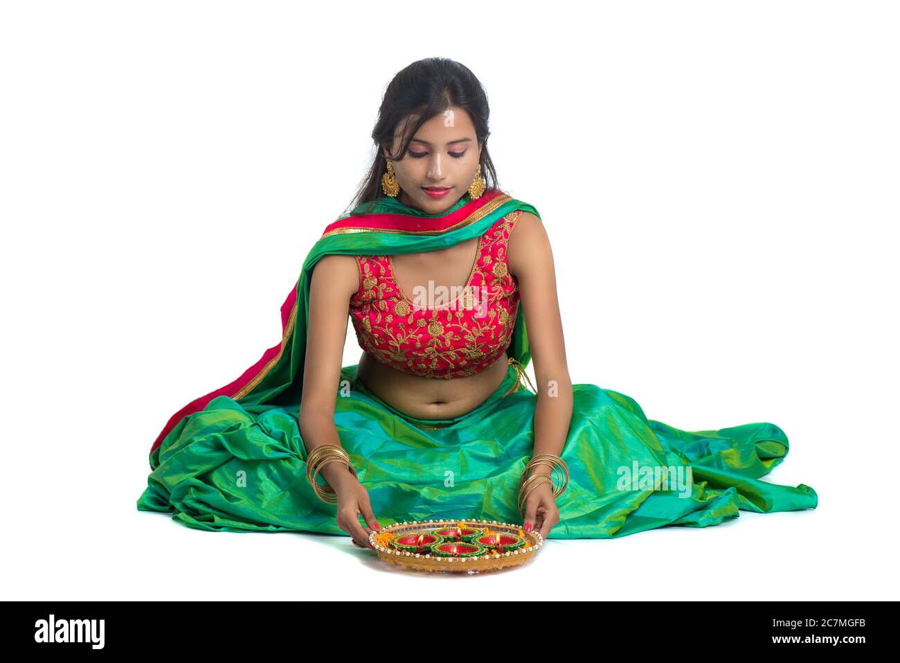 Portrait of a Indian Traditional Girl holding Diya and making Rangoli
