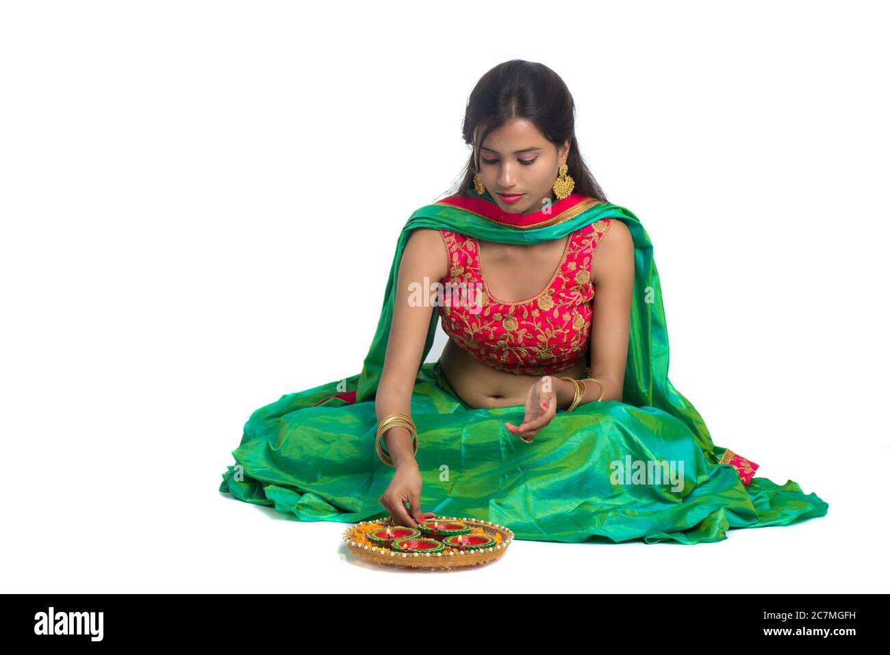 Portrait of a Indian Traditional Girl holding Diya and making Rangoli