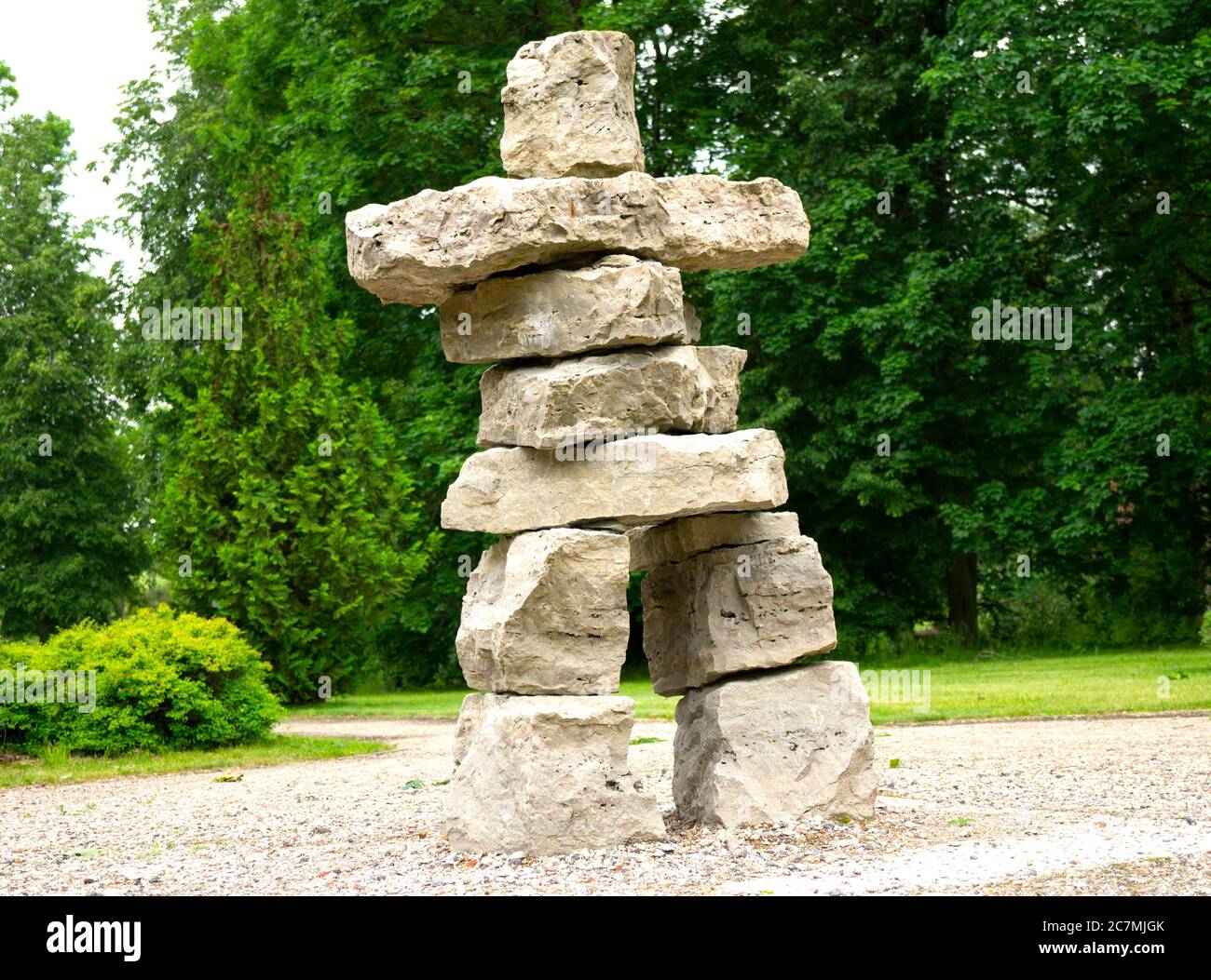 primitive simple big huge man sculpture from bright square stones park summer Stock Photo