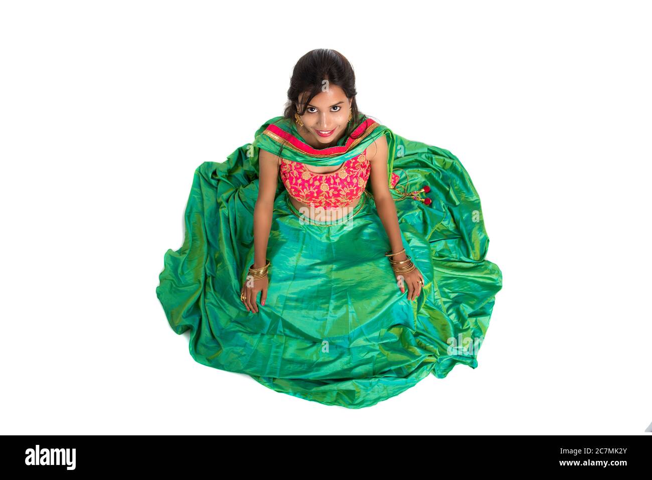 Beautiful Indian traditional girl sitting and posing on white