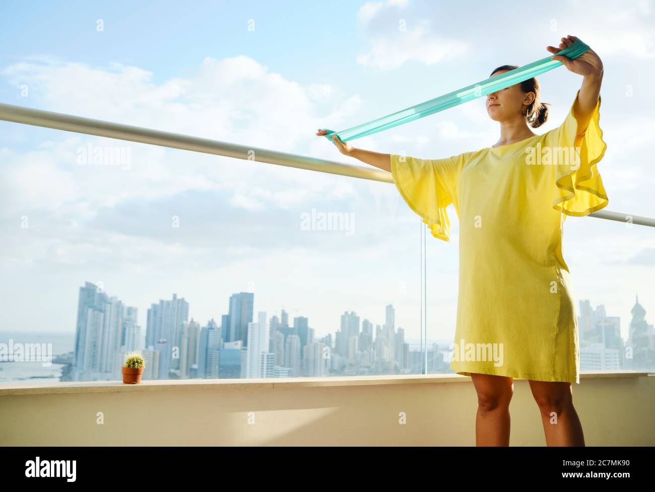 Pregnant Woman Exercising With Rubber Band At Home Stock Photo