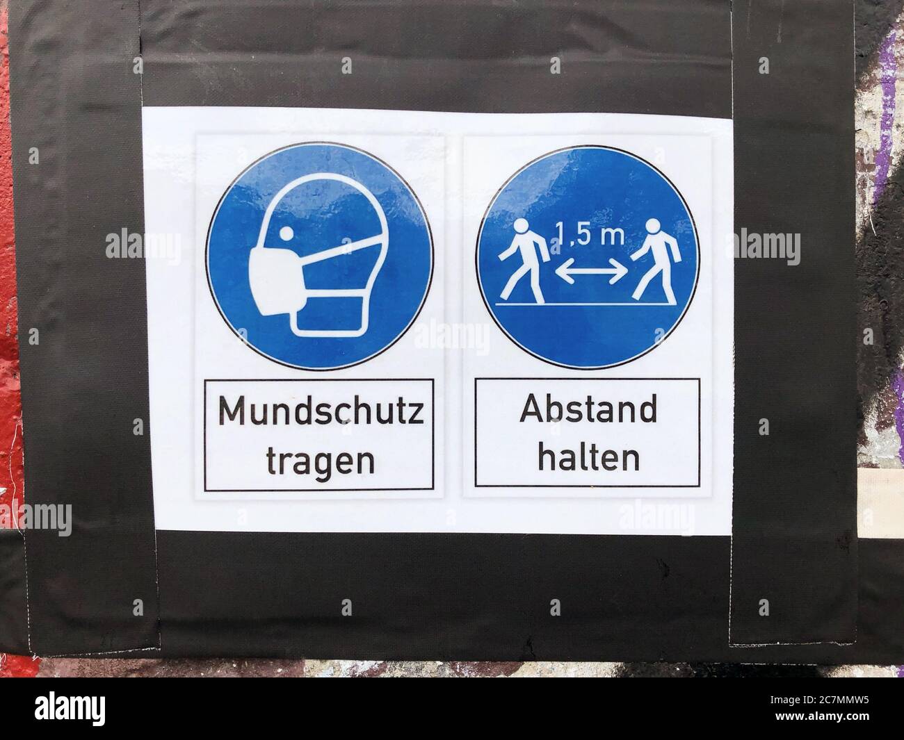 wear face mask and keep distance sign with (german: Mundschutz tragen - Abstand halten ) Stock Photo