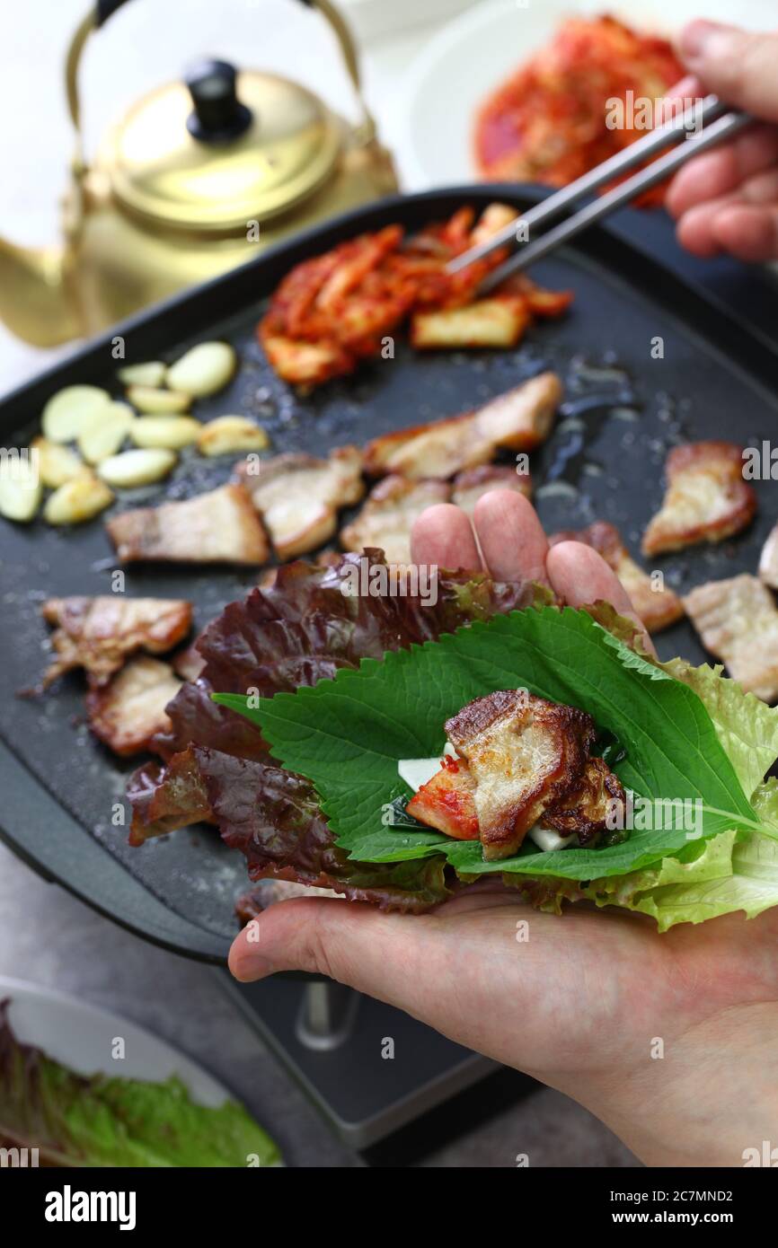 cooked samgyeopsal ( grilled pork belly BBQ ), wrapping with lettuce Stock  Photo - Alamy