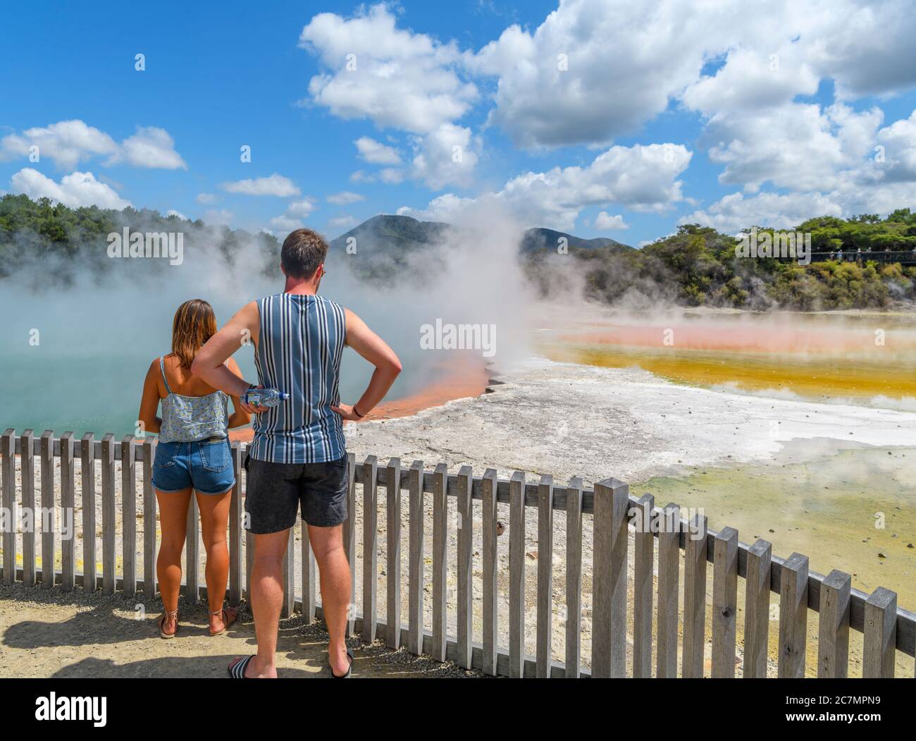 Couple by the Champagne Pool hot spring at Wai-O-Tapu Thermal Wonderland, near Rotorua, New Zealand Stock Photo